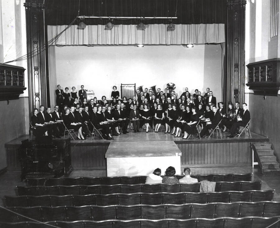 The University Concert Band sits for a group photo wearing concert black in the Administration Auditorium.