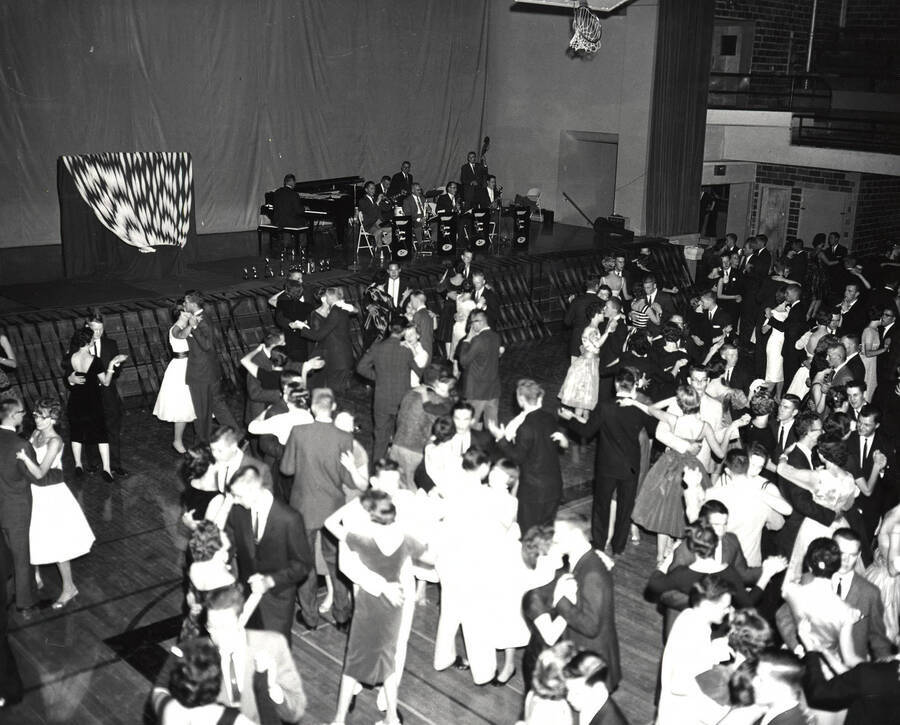 Students in formal wear dance in the Memorial Gym during the Homecoming festivities.