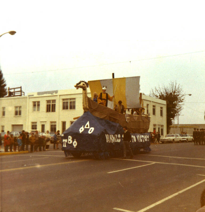 A color photo of Pi Beta Phi's and Phi Delta Theta's Viking themed Homecoming parade float. Photographer