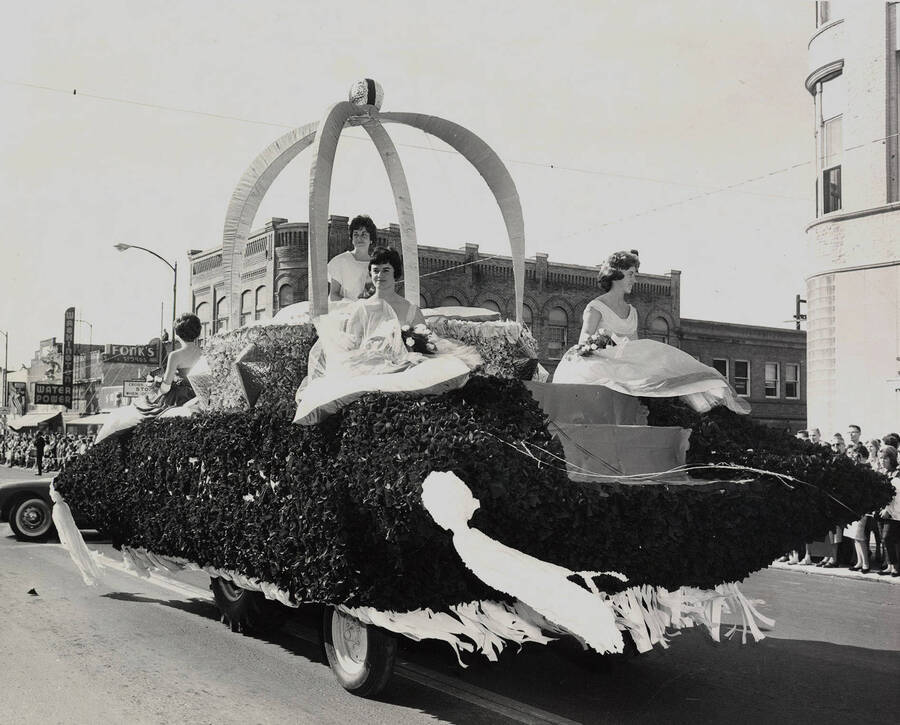 Homecoming queen Toni Thunen and Homecoming princesses  Marge Marshall and Eleanor Unzicker ride on top of a float in the Homecoming parade.