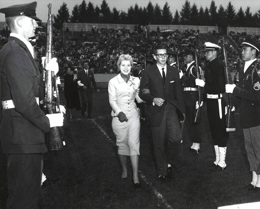 Charmaine Deitz, Homecoming queen, is escorted across the football field at the Homecoming game.