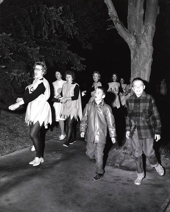 Members of the Delta Delta Delta sorority and two young boys lead the pajama parade the night before the Homecoming game.