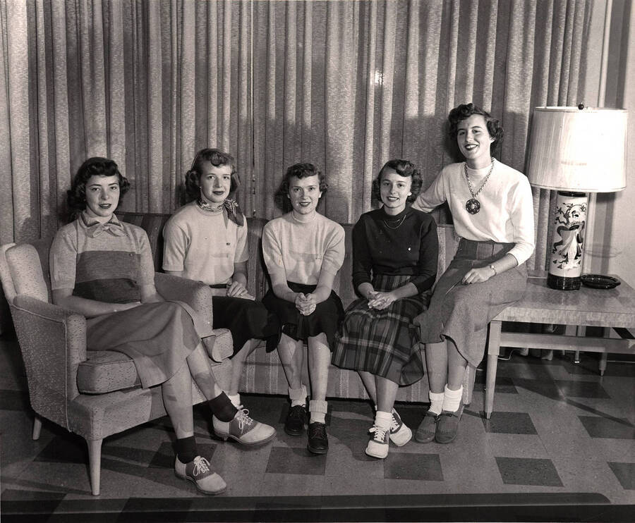 Homecoming queen nominations Shirlie Vorous, Madeline Meltvedt, Margery Nobles, Emily Christie, and Betty Westerberg, sit together in a living area.