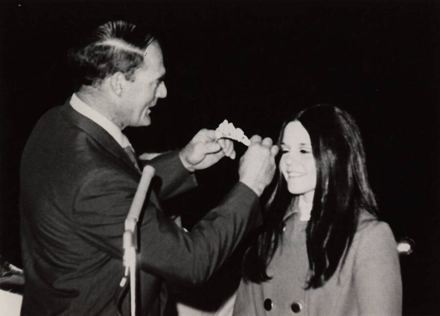 An unidentified man crowns Glennis Connor as Homecoming Queen.