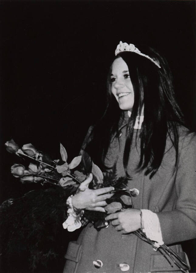 Glennis Connor, Homecoming Queen, poses for a photograph with her crown and a bouquet of roses.