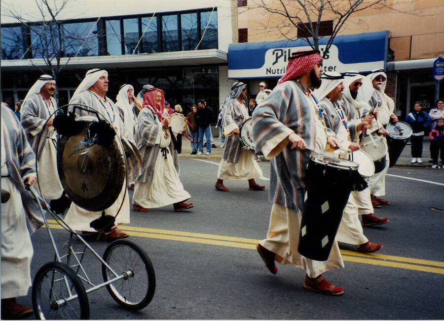 Men play drums and other percussion instruments dressed in traditional Middle Eastern costumes as part of the Homecoming parade.