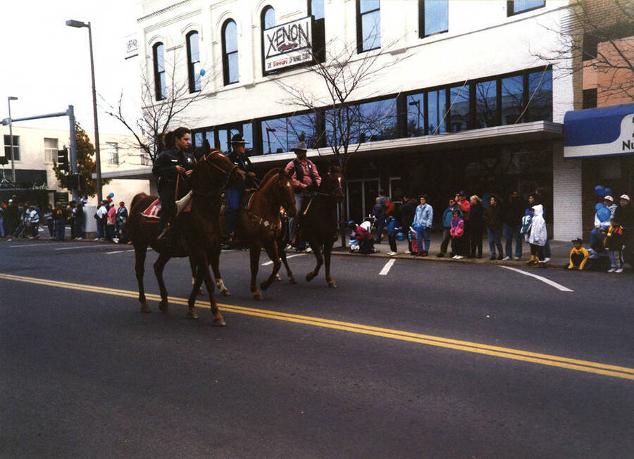 Three police officials ride on horseback in the Homecoming parade.