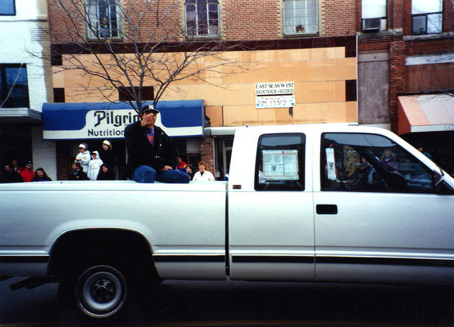 An unidentified man waves at spectators from the bed of a truck in the Homecoming parade.
