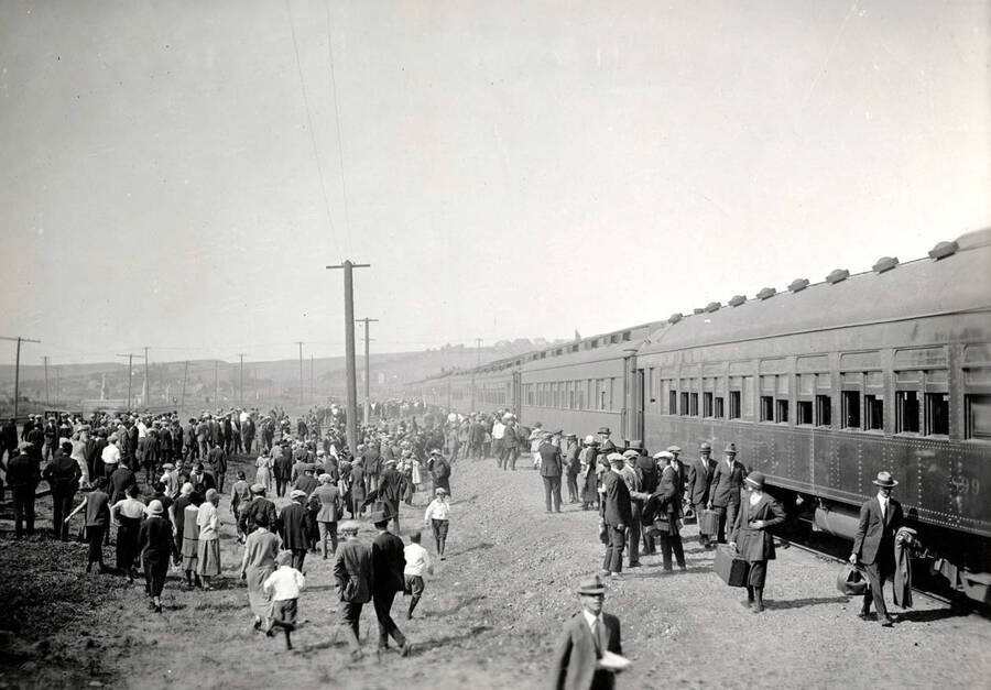 A shot of a train coming into Moscow from the south. Several people stand, cluttered, watching it arrive.