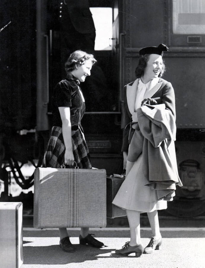 Two women laugh as they converse outside of the Student Special train.