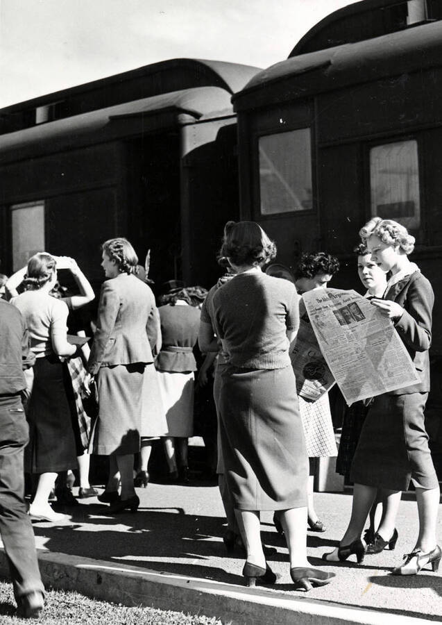 One woman reads The Argonaut while others stand waiting for fellow students to disembark from the Student Special train.