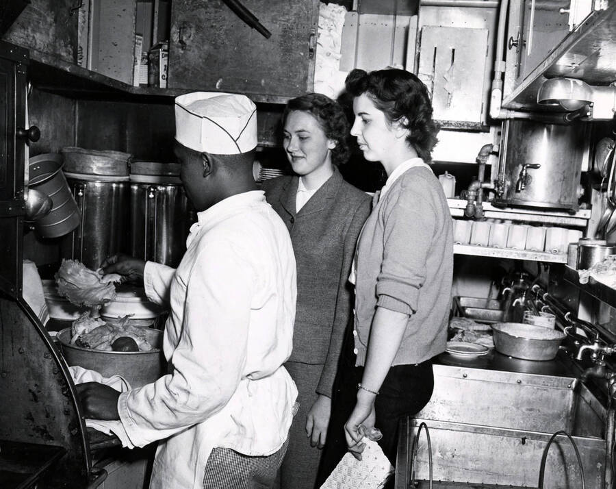 Barbara Heyer (center) and Joyce Ann Merrel watch the Student Special train's head chef prepare a stock.