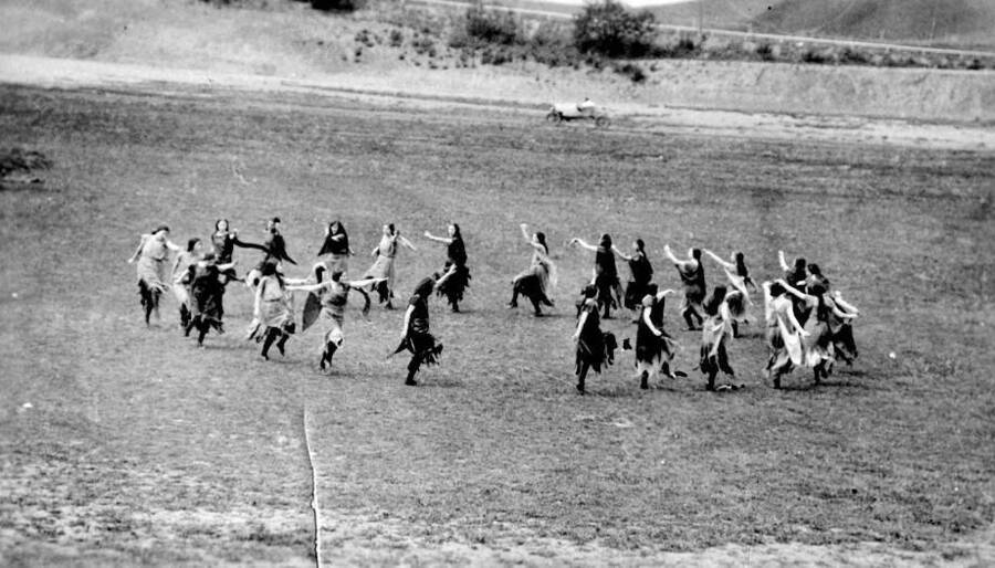 A group of people dressed as Native Americans dance in a circle in a field for the Light on the Mountains pageant.
