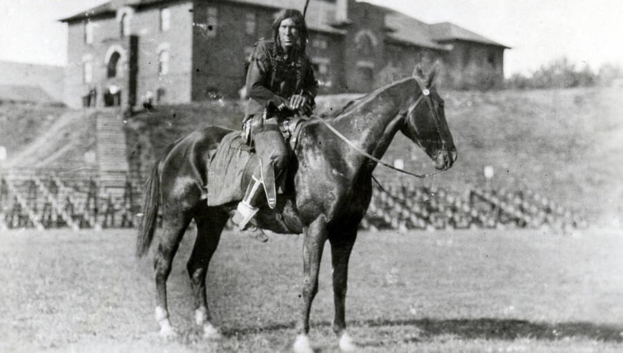 An unidentified man sits atop a horse on MaClean Field, dressed in traditional Native American wear for the Light on the Mountains pageant.