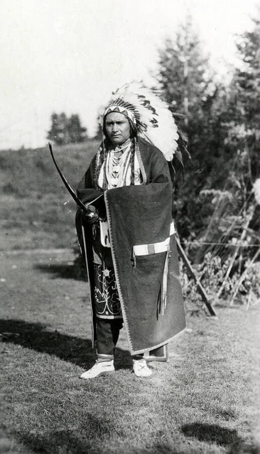 An unidentified man dressed as a traditional Native American chief poses holding a weapon for the Light on the Mountains pageant.