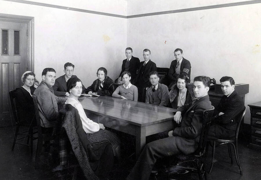 The executive board of the ASUI sits around a table and poses for a photograph. Students pictured: Lionel Campbell (ASUI President), Harry Robb (Vice President and Vice Chairman of the Executive Board), Marthalene Tanner (secretary), Charles Heath, Parker Wickwire, Austa White, Elizabeth Taylor Dick, Robert Harris, Howard Altnow, Norma Longeteig, and Charles Keating.