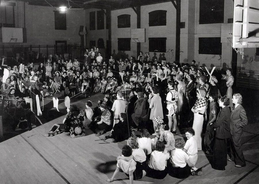 Students attending a co-ed prom gather to watch a speaker/performer on stage.