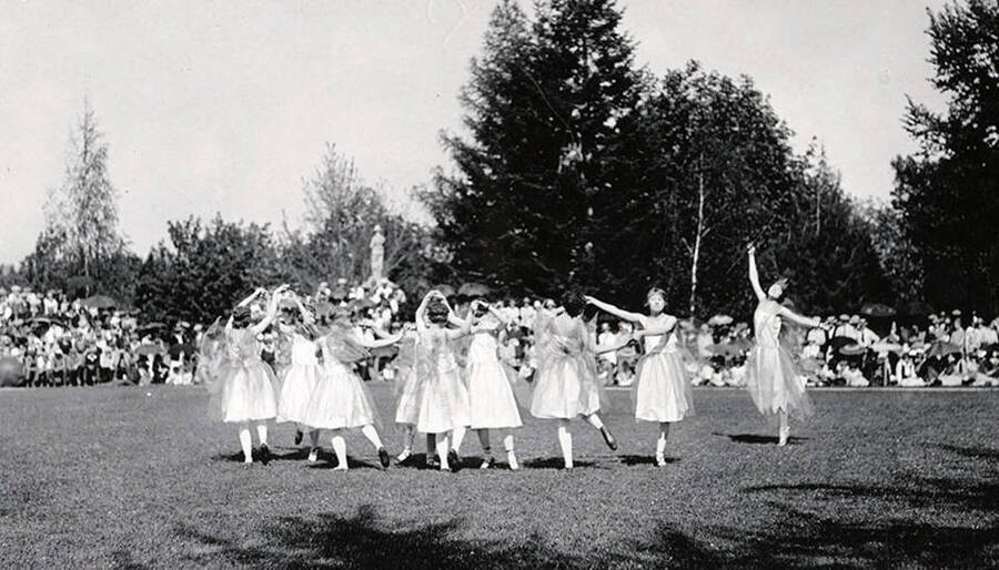 A group of women dance in a circle while a crowd of spectators watch during Idaho's Campus Day celebrations.