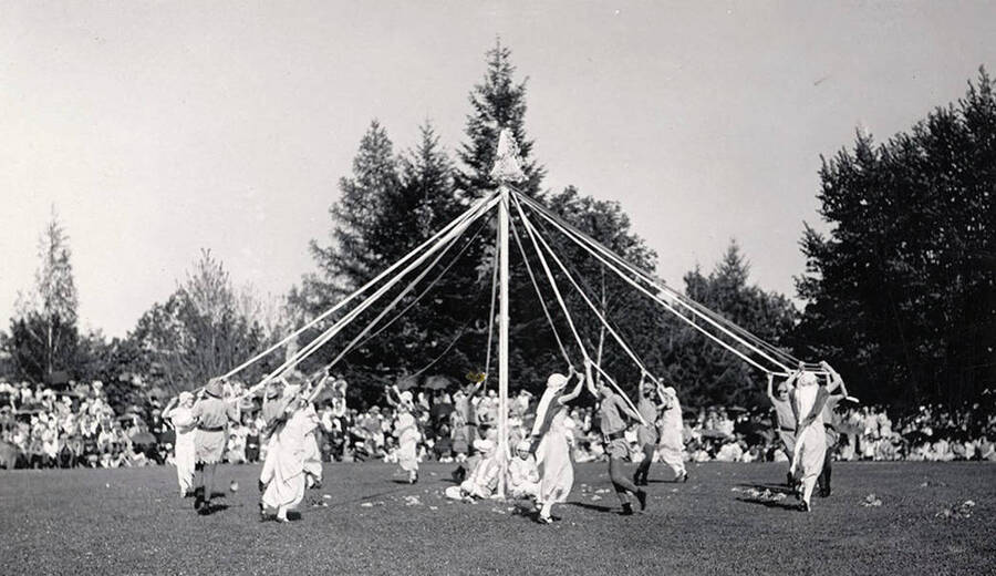 Students watch performers wrap a post with ribbons in what is known as the Maypole dance during Idaho's Campus Day celebrations.