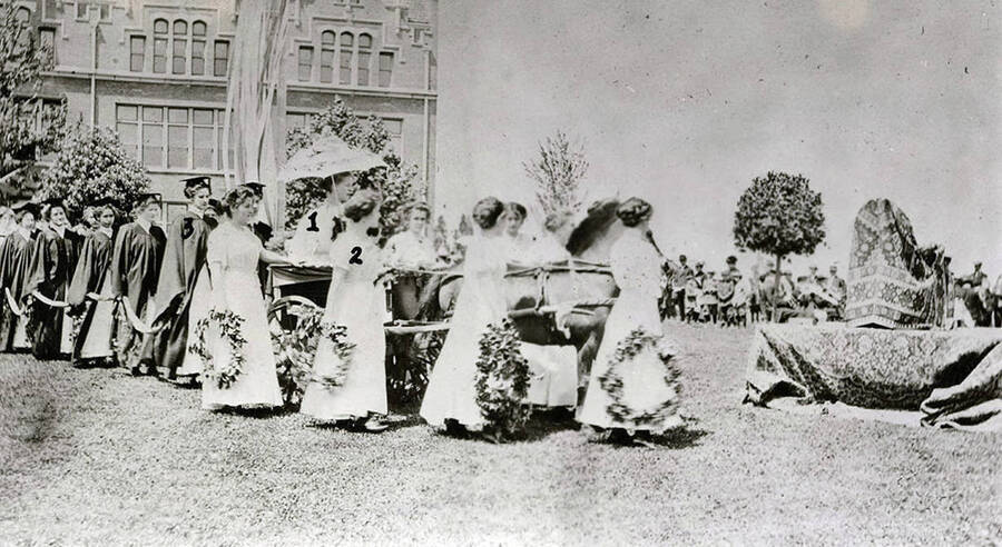 Students lead a horse, participating in the procession of the May Queen during Idaho's Campus Day celebrations. Students pictured: 1) Bess Dunn, 2) Sadie Stockton, 3) Gretchen Zumhoff.