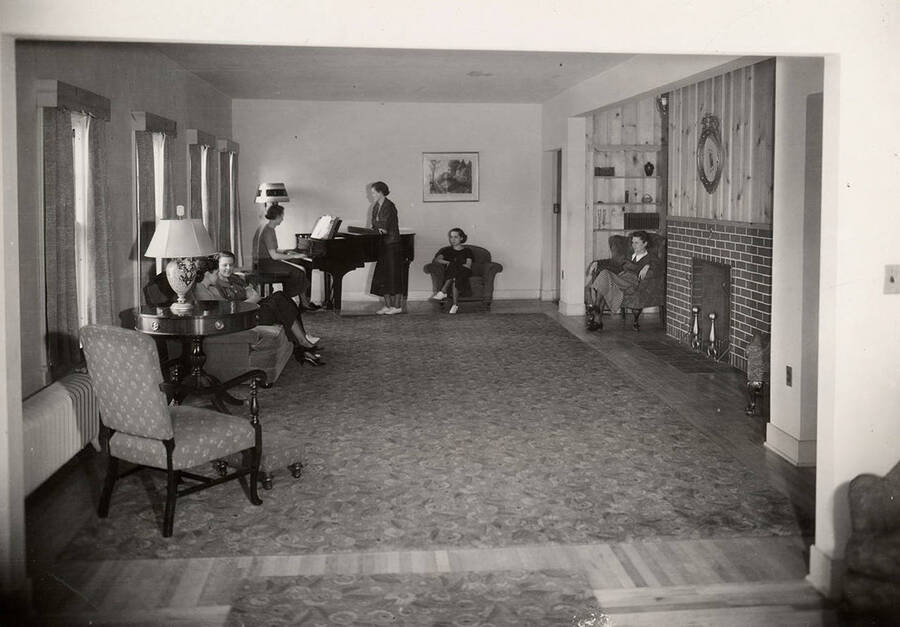 Students sitting around the living room in the Alpha Chi Omega house.