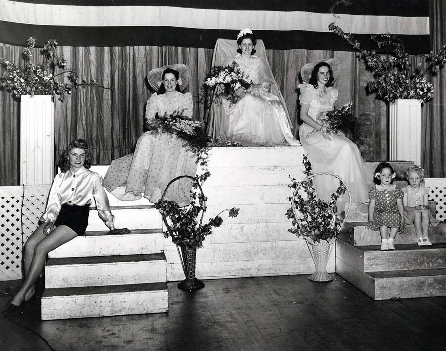 The May Queen sits with her court. L-R: Merrie Lu Kloepfer (Page), Jean Mann (Maid of Honor), Vera Nell James (May Queen), Pauline Hawley (Maid of Honor).