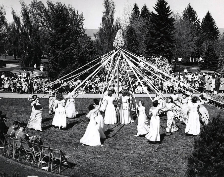 Students sit on the Administration Lawn, watching the winding of the maypole during Mother's Day weekend festivities.