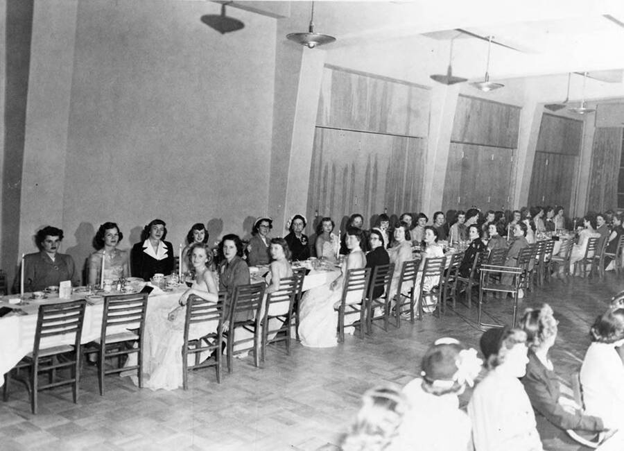Women wearing formal dress sit together at banquet tables during the Kappa Alpha Theta banquet.