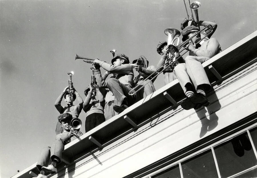 Brass players in the pep band on play a roof.