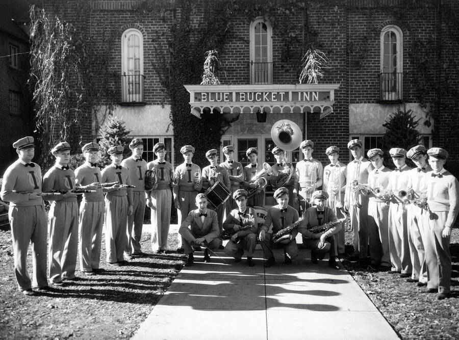 Pep band director W.E. Chase is pictured as Idaho's pep band poses in uniform outside of the Blue Bucket Inn, what is now the Bruce Pittman Center.