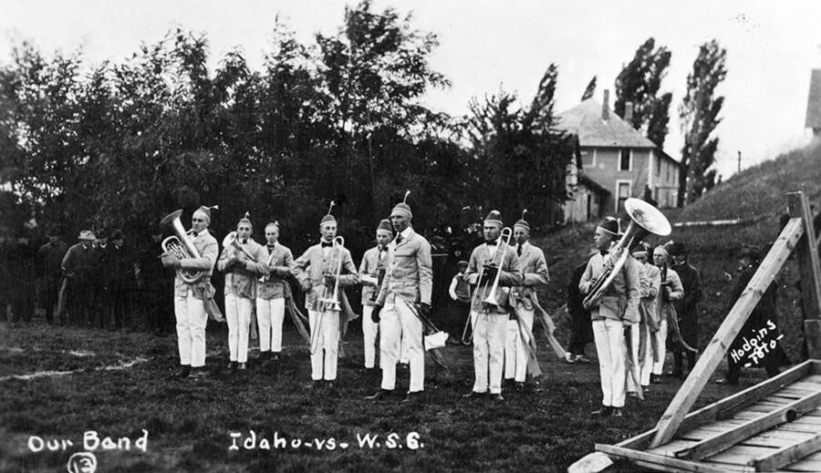 The Idaho pep band stand on the hill south of MacLean Field in preparation for their performance. Caption reads: #13, Our Band, Idaho vs. W.S.C.
