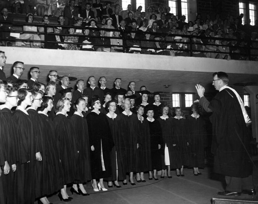University of Idaho's concert choir, the Vandaleers, perform while a crowd watches from the balcony of Memorial Gymnasium.
