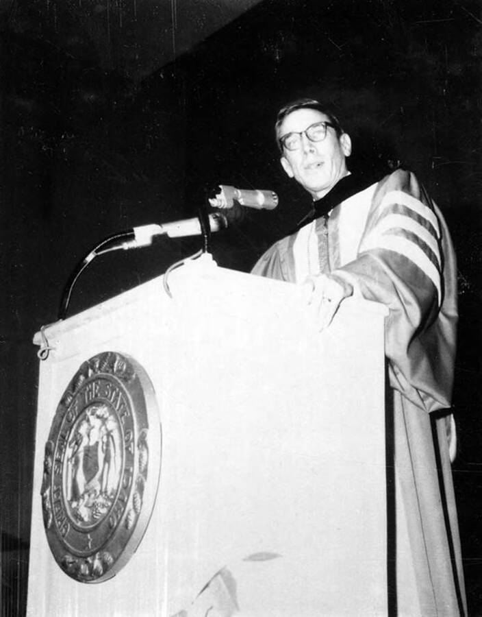 Washington State President Dr. Glen R. Terrell stands at the podium giving a speech during University of Idaho's commencement.