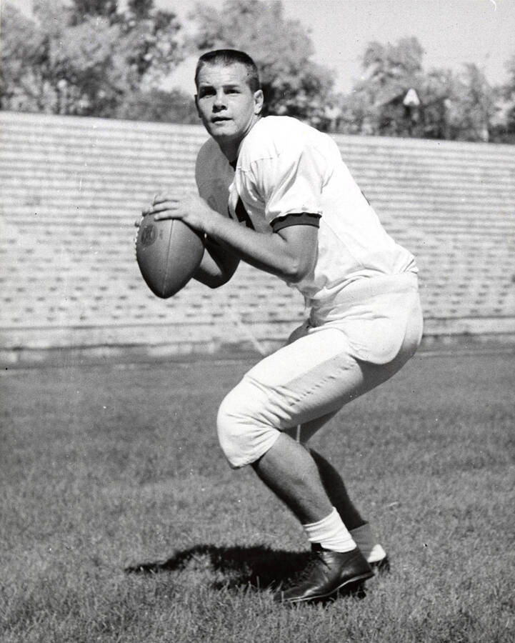 Football player Rick Dobbins (quarterback) preparing to throw the football on the University of Idaho field.