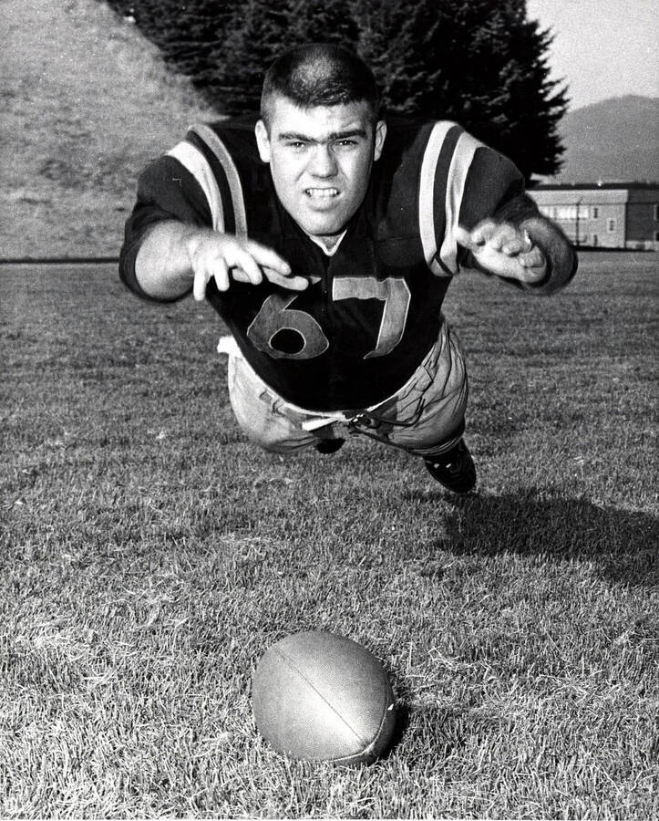 Football player Dick Monahan (guard) diving for the ball at the University of Idaho.