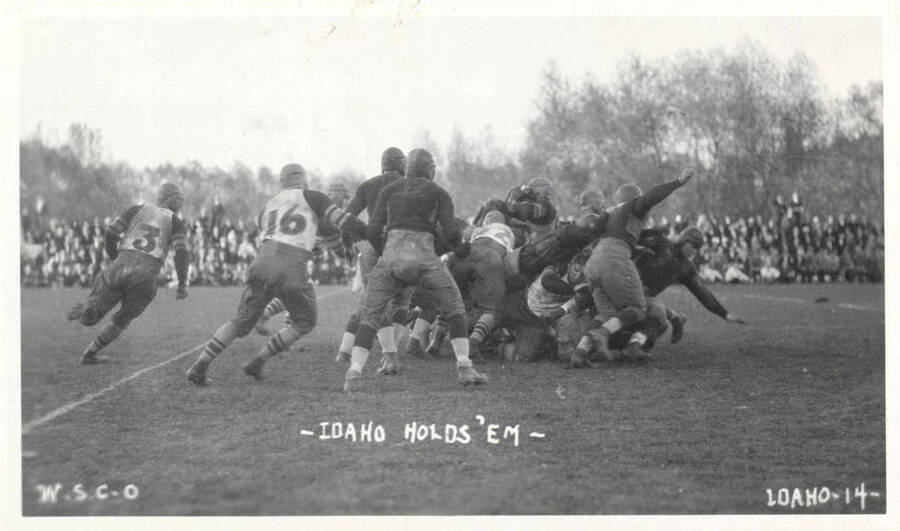 A photo taken during a University of Idaho vs. Washington State College football game with a caption that reads, 'W.S.C.-0 ~Idaho Holds 'Em~ Idaho-14.'