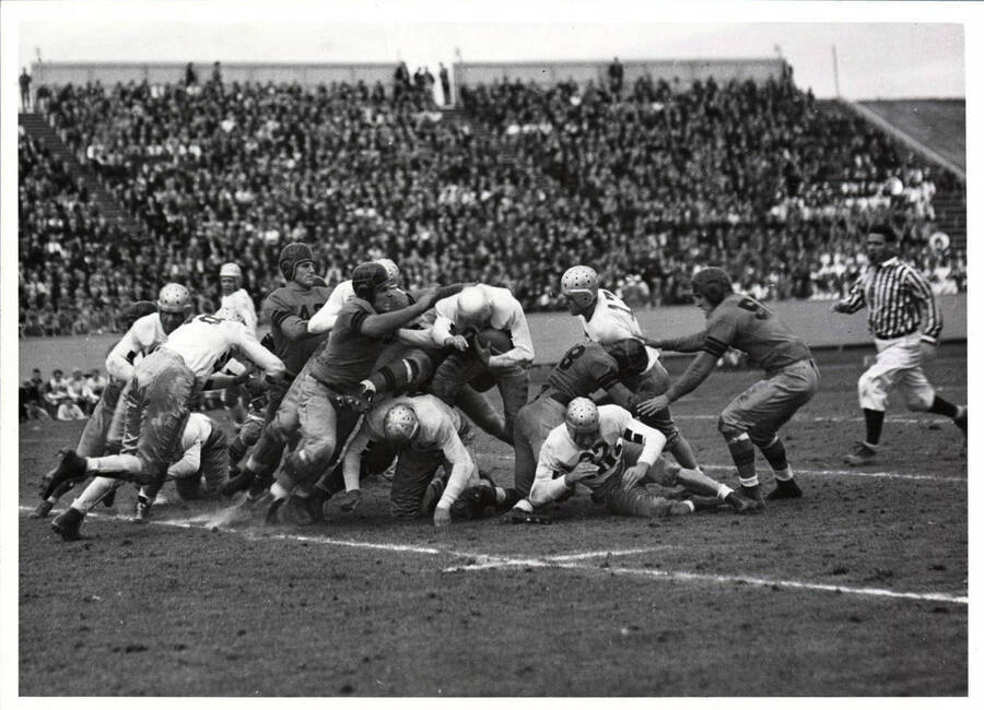 The crowd watches an intense tackle as the referee runs to disassemble the dog pile during the Idaho and North Dakota State football game that ended 27-0.