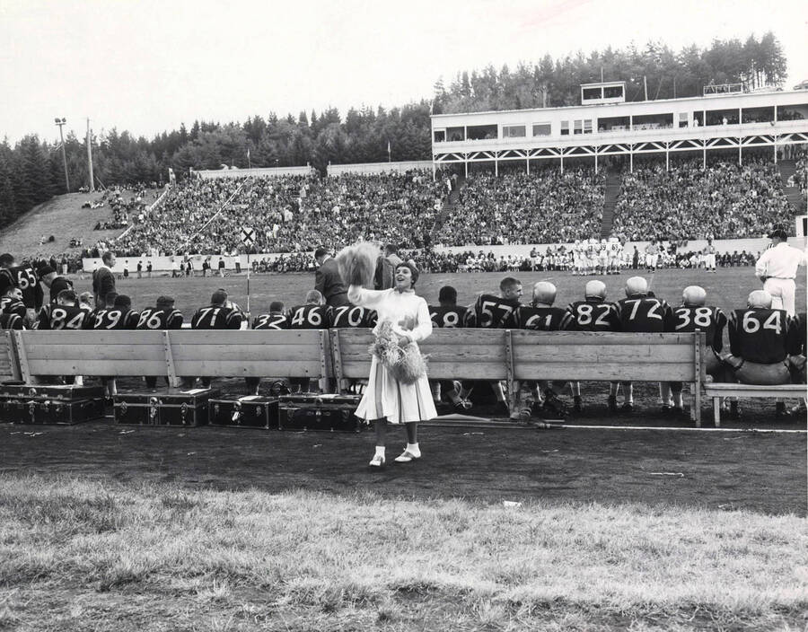 Dolores Hormaechea leading cheer at football game for the University of Idaho in front of a large crowd.