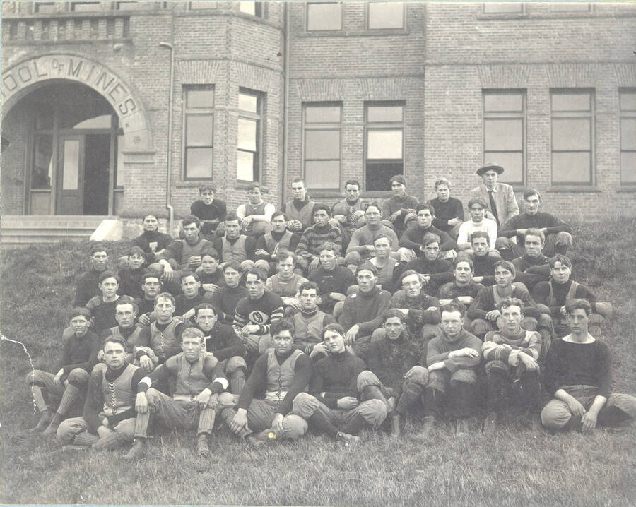 Photograph featuring the 1908 football team posing in front of the former School of Mines building, which once stood where Niccolls now is.
