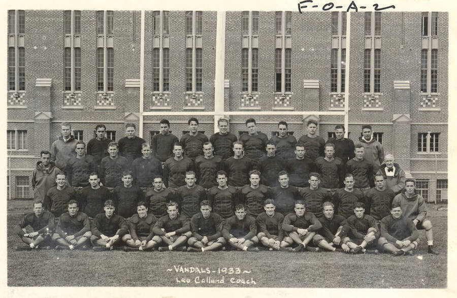 Photograph featuring the 1933 Idaho Vandals football team posing in front of the Memorial Gymnasium.