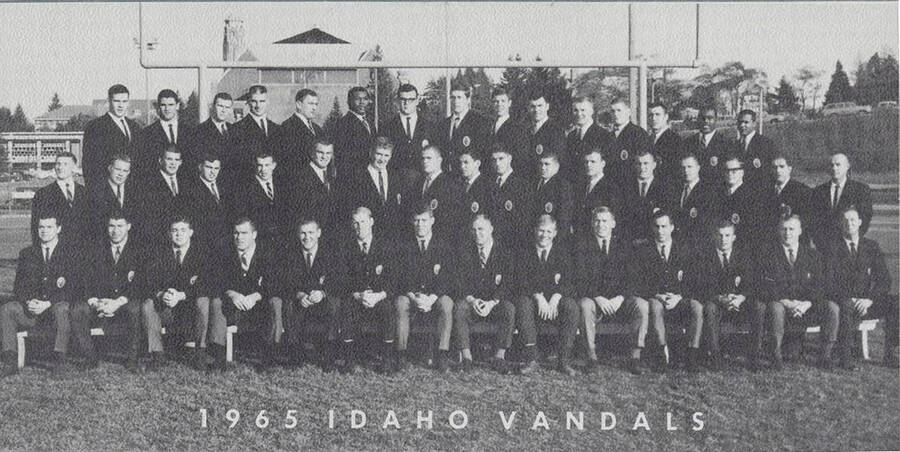 The 1965 Idaho football team poses in suits for a team photograph on MacLean Field.