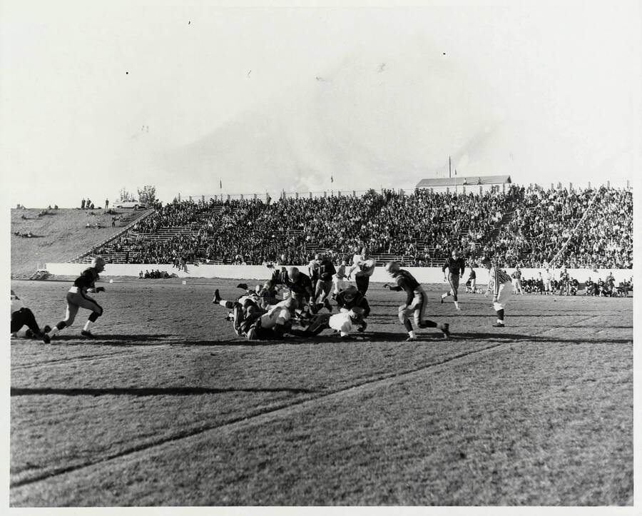 A San Jose State running back is tackled by several Idaho defenders.