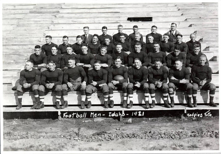 Photograph of the University of Idaho Varsity football team sitting on the bleachers. Caption reads 'Football Men - Idaho - 1921.'