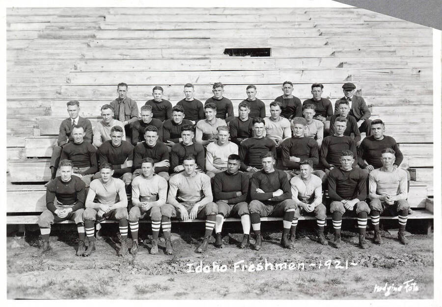 Photograph of University of Idaho freshman football team sitting on the bleachers. Caption reads 'Idaho Freshmen - 1921.'