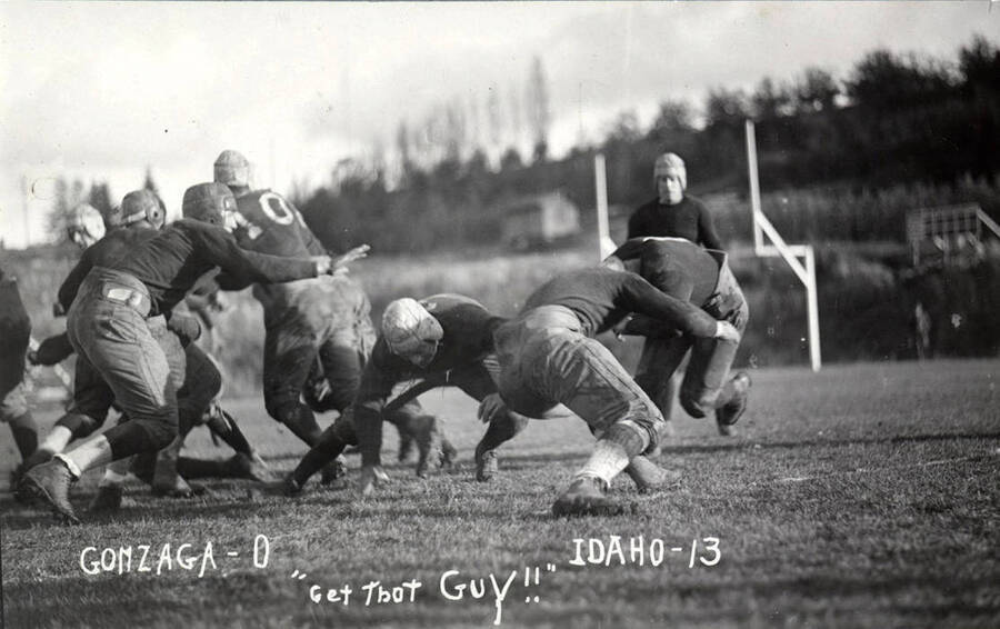 Photograph of the University of Idaho versus Gonzaga football game. Caption reads 'Gonzaga-0, Idaho-13, 'Get That Guy!!''