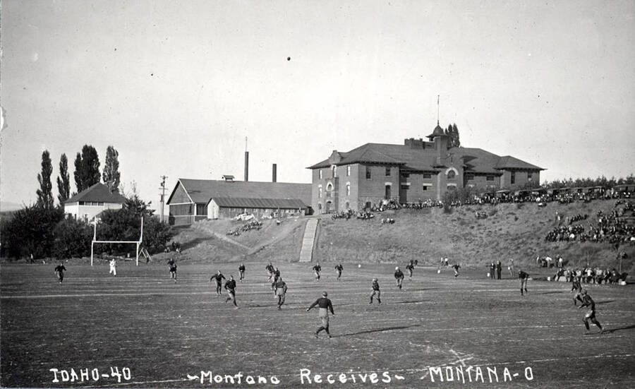 Photograph of the University of Idaho versus Montana football game. Caption reads 'Idaho-40 ~Montana Receives~ Montana-0.'