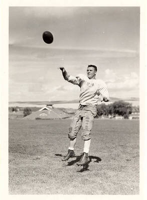 Right halfback Earl Acuff for the University of Idaho, mid-air after throwing the football.