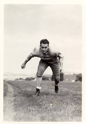 Glenn Rathbun, tackle for the University of Idaho football team, running towards the camera on the football field.