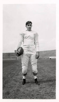 Merlin Powell, a freshman on the University of Idaho football team, standing on the field with a ball.