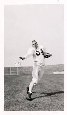 Don Wisdom (#54), a freshman football player for the University of Idaho, running with a football.
